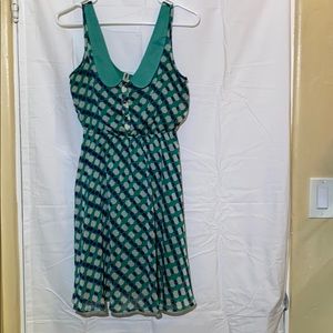 Women’s dress: green with beige and blue circles.